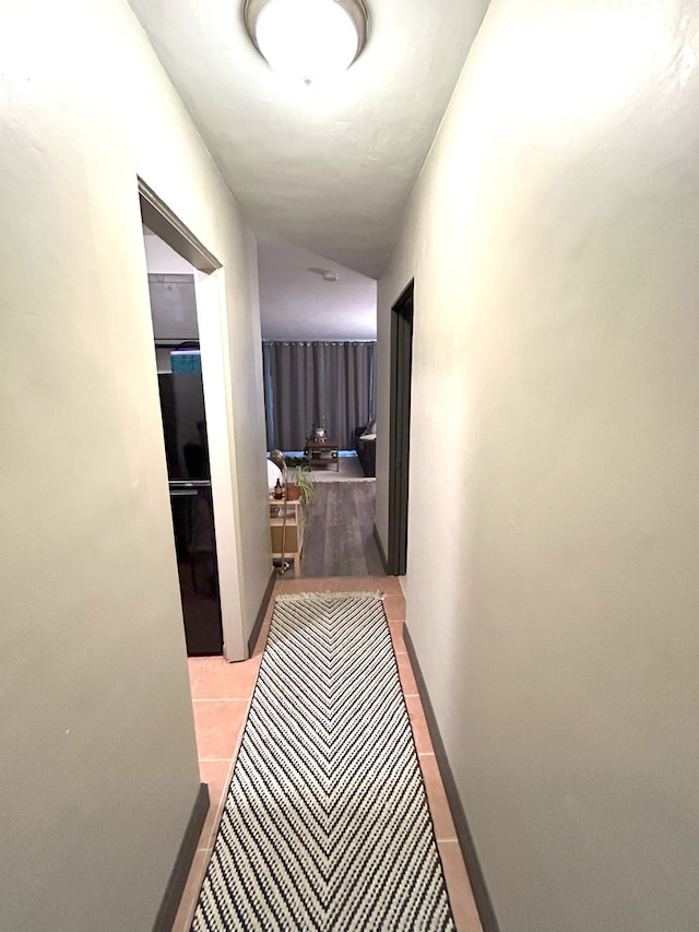 hallway featuring baseboards and tile patterned floors