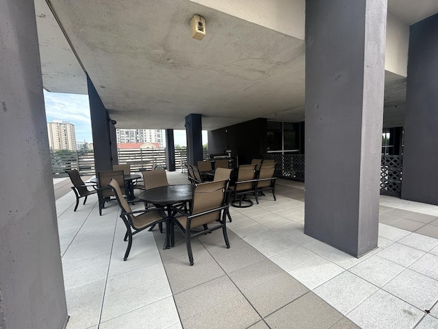 view of patio with outdoor dining area and a city view