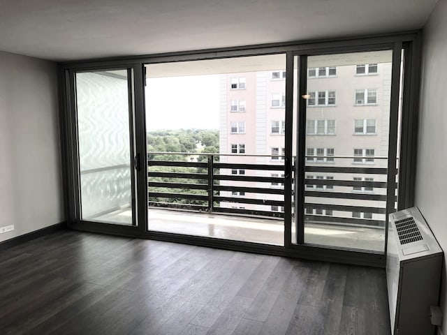 entryway featuring a wall of windows, baseboards, and wood finished floors