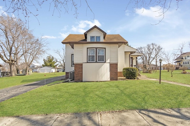 619 Lincoln St, Minonk, IL 61760 - view of front of house featuring brick siding, central air condition unit, driveway, and a front lawn