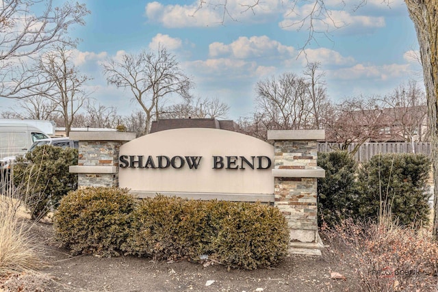 community / neighborhood sign with fence