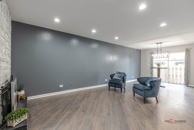 living area featuring recessed lighting, a fireplace, wood finished floors, and baseboards