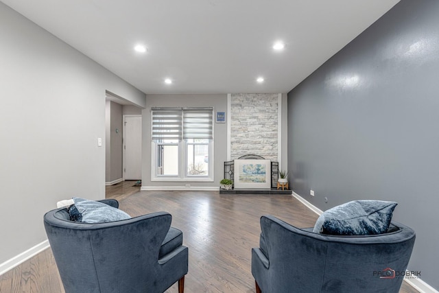 living room with recessed lighting, a fireplace, baseboards, and wood finished floors