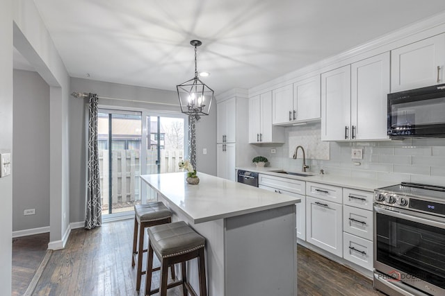 kitchen with stainless steel appliances, tasteful backsplash, a sink, and white cabinetry