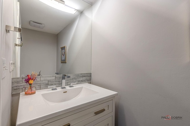 bathroom with visible vents, backsplash, and vanity