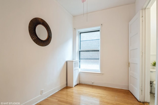 unfurnished room with baseboards and light wood-style floors