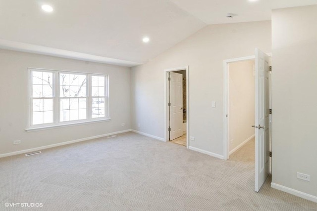 unfurnished room featuring lofted ceiling, light colored carpet, baseboards, and recessed lighting