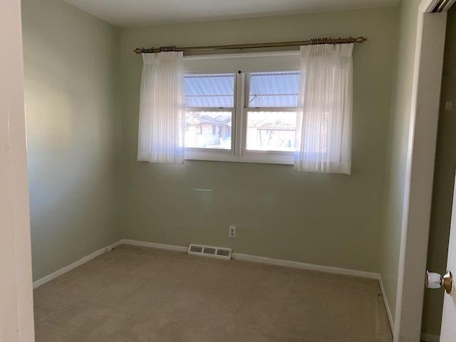 carpeted empty room with baseboards and visible vents