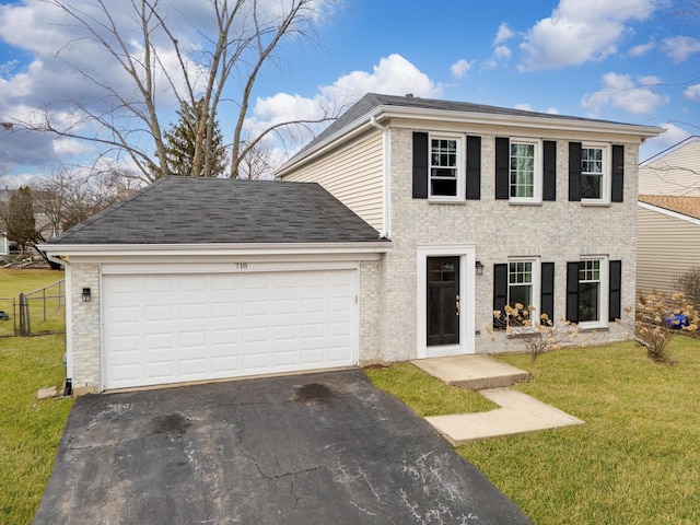 colonial-style house with a garage, driveway, fence, a front lawn, and brick siding