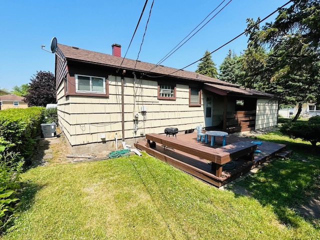 rear view of house featuring a chimney, central AC unit, a lawn, and a wooden deck