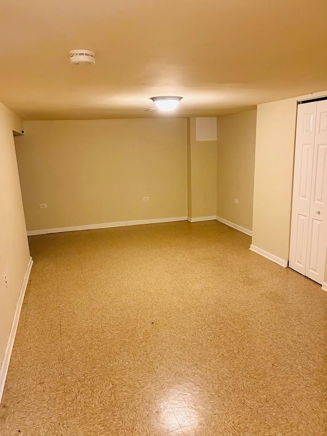 finished below grade area featuring baseboards and tile patterned floors