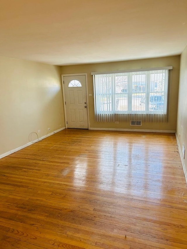 entryway with baseboards, visible vents, and wood finished floors