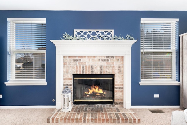 interior details with visible vents, a fireplace, baseboards, and carpet