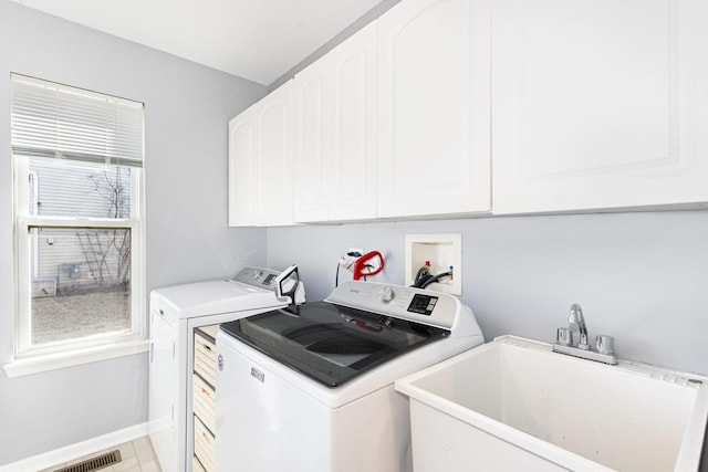 washroom featuring visible vents, independent washer and dryer, a sink, cabinet space, and baseboards