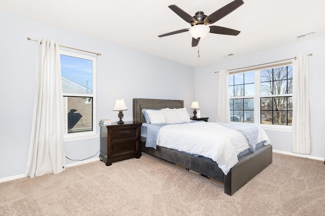 bedroom with light carpet, visible vents, a ceiling fan, and baseboards