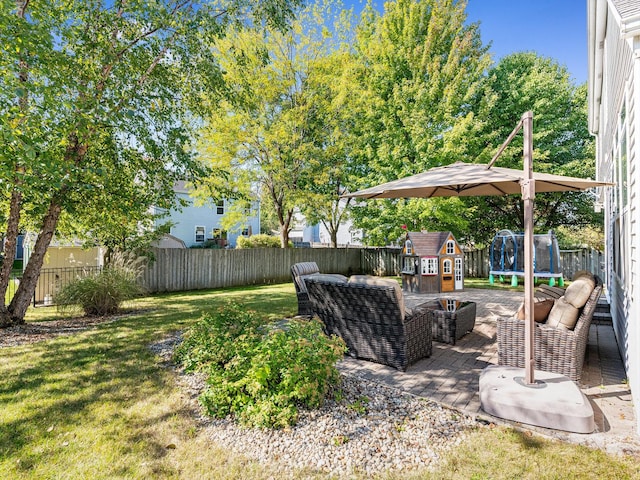 view of yard with outdoor lounge area, a patio area, a trampoline, and a fenced backyard