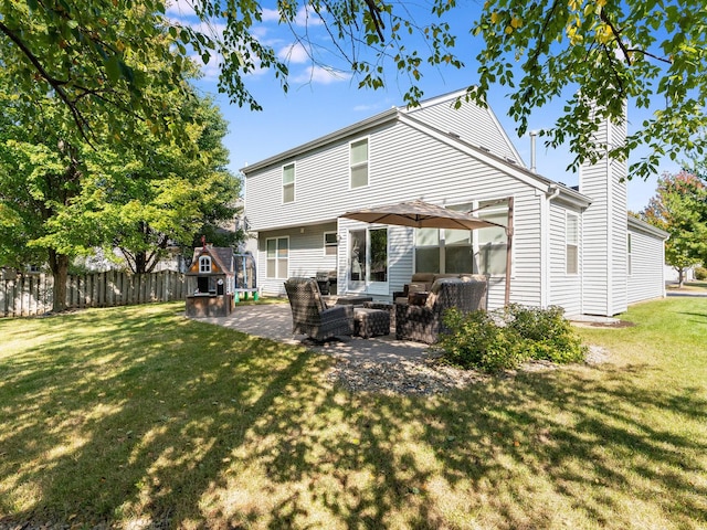 back of property with outdoor lounge area, a patio, a yard, and fence