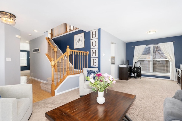 carpeted living room with stairway and baseboards