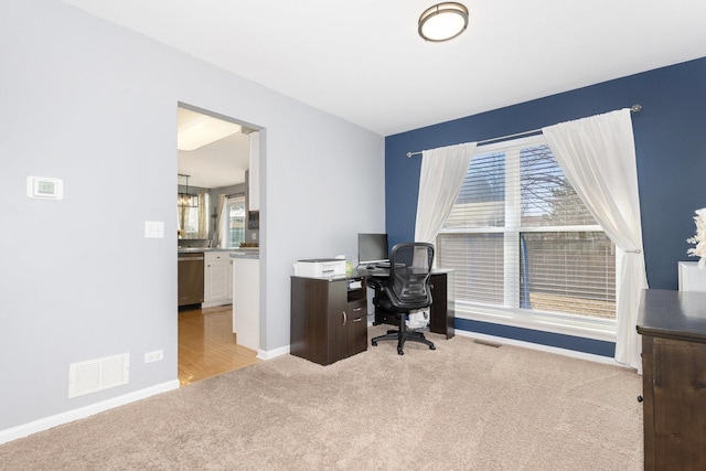 carpeted office featuring visible vents and baseboards