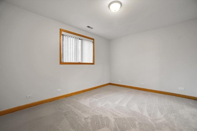 empty room featuring carpet floors, visible vents, and baseboards