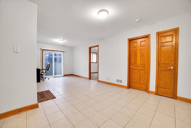 unfurnished room with light tile patterned floors, visible vents, and baseboards