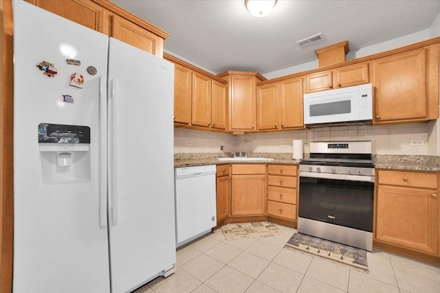 kitchen featuring white appliances, visible vents, decorative backsplash, a sink, and light tile patterned flooring