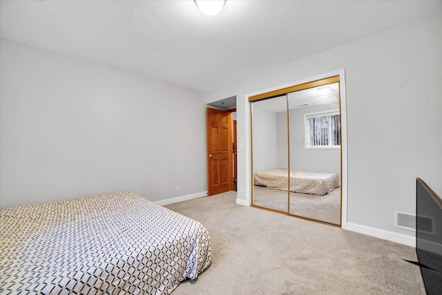 bedroom featuring a closet, carpet flooring, visible vents, and baseboards