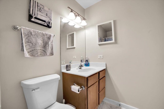 bathroom with baseboards, vanity, and toilet