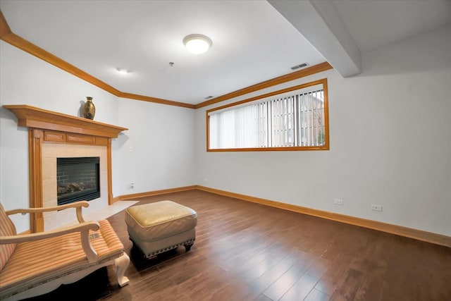 sitting room featuring a fireplace, wood finished floors, visible vents, baseboards, and crown molding