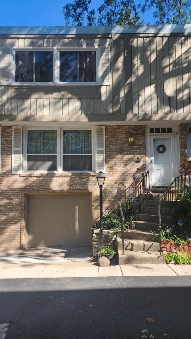 view of property with brick siding and an attached garage