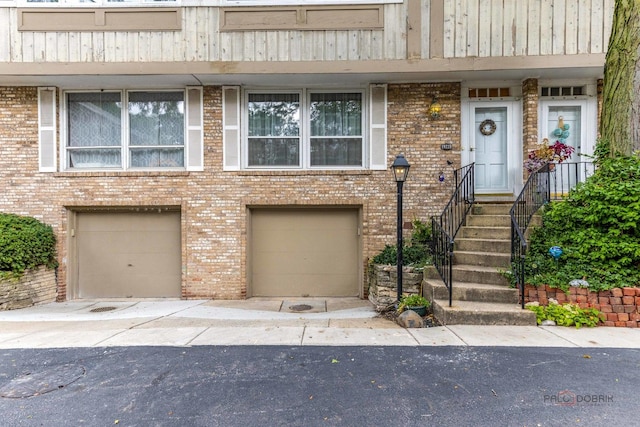 townhome / multi-family property with brick siding and a garage