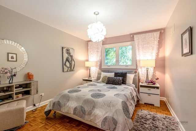 bedroom with an inviting chandelier and baseboards