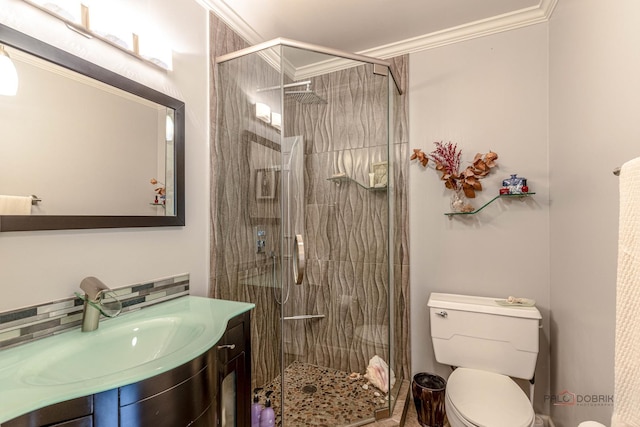 bathroom featuring vanity, toilet, a stall shower, and ornamental molding