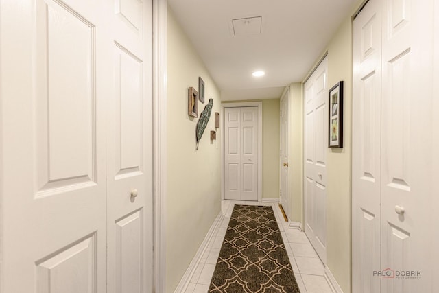 hall with light tile patterned floors, baseboards, and recessed lighting