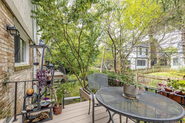 wooden terrace featuring outdoor dining space and fence