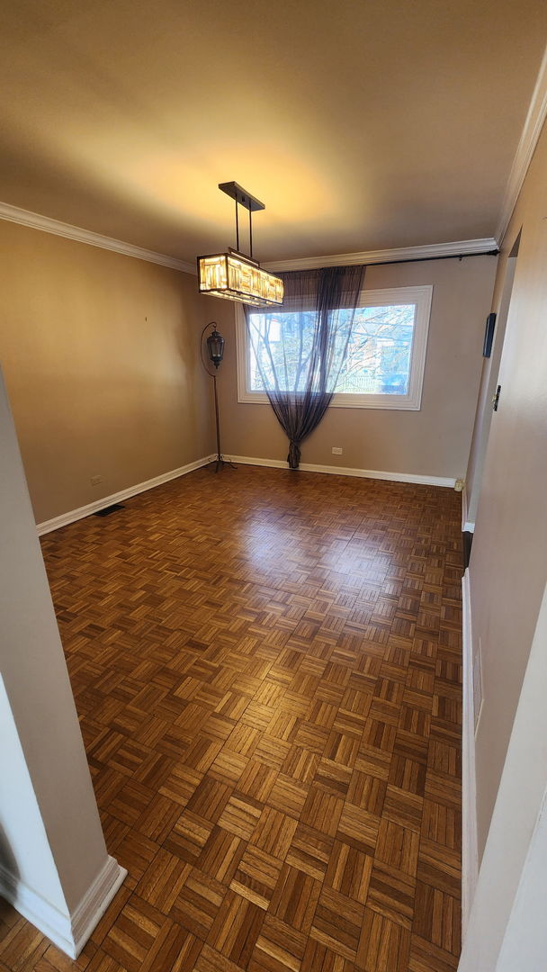 unfurnished dining area featuring baseboards and crown molding