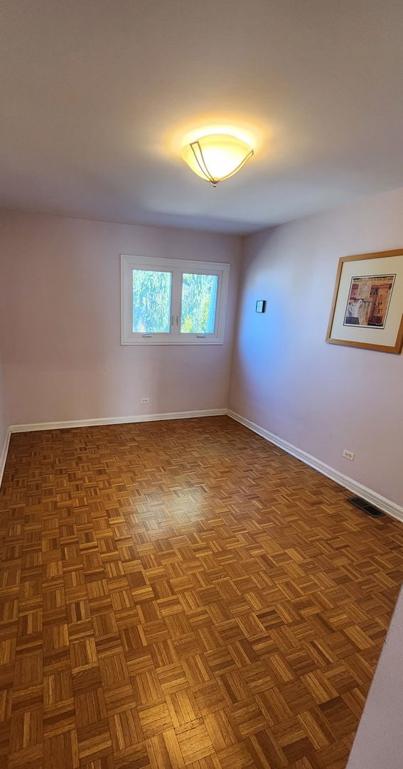 unfurnished room with visible vents and baseboards