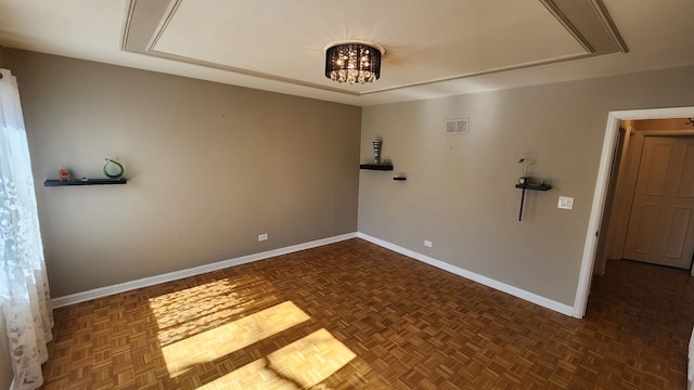 unfurnished room featuring visible vents, baseboards, and an inviting chandelier