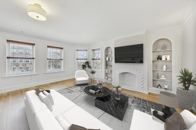 living area featuring a fireplace, built in features, and wood finished floors