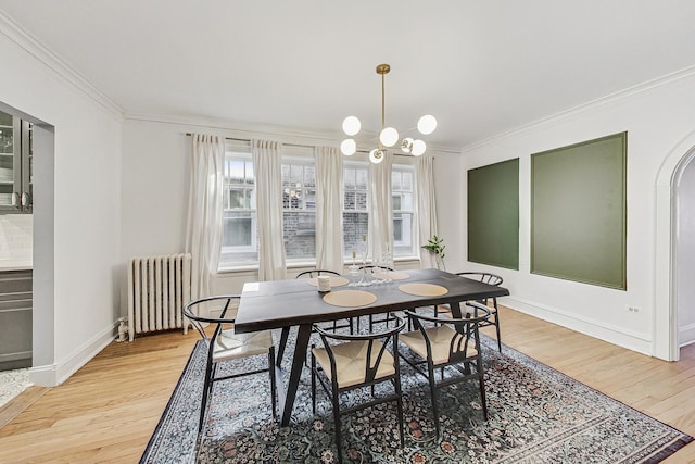 dining space with baseboards, radiator, crown molding, light wood-type flooring, and a chandelier