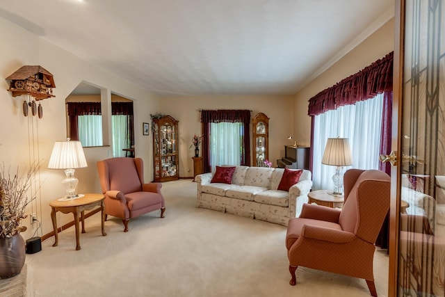 carpeted living area featuring baseboards