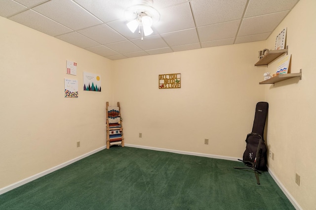 spare room featuring dark colored carpet, baseboards, and a paneled ceiling