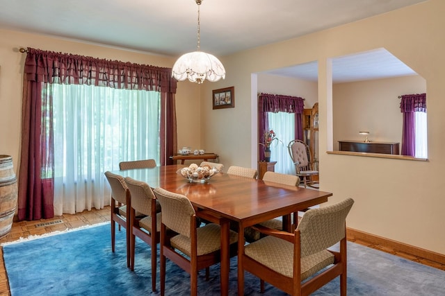 dining room featuring a notable chandelier, baseboards, and visible vents