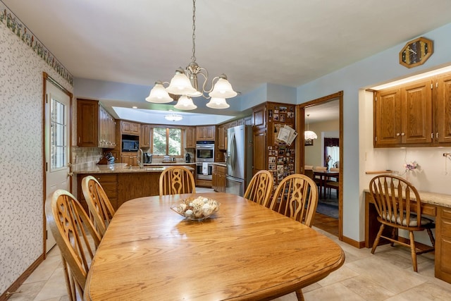 dining room featuring wallpapered walls, baseboards, and a chandelier