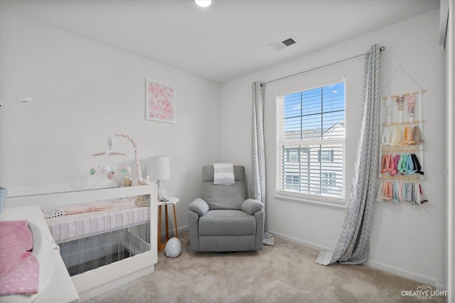 bedroom with visible vents, a nursery area, carpet, and baseboards