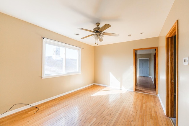 spare room featuring light wood-style flooring, baseboards, visible vents, and ceiling fan