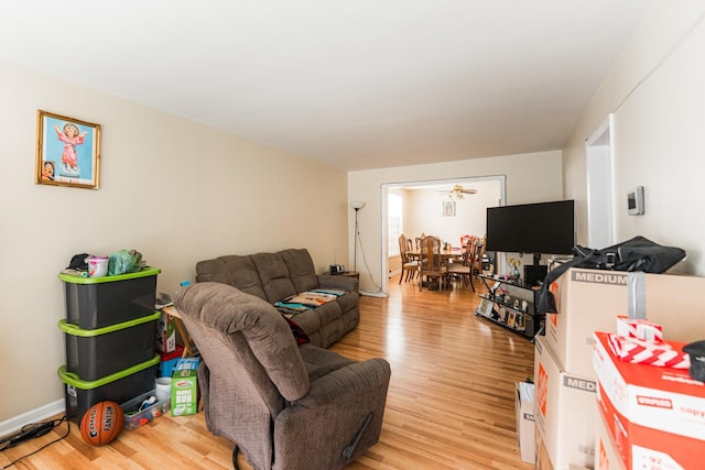 living area featuring baseboards and light wood-type flooring