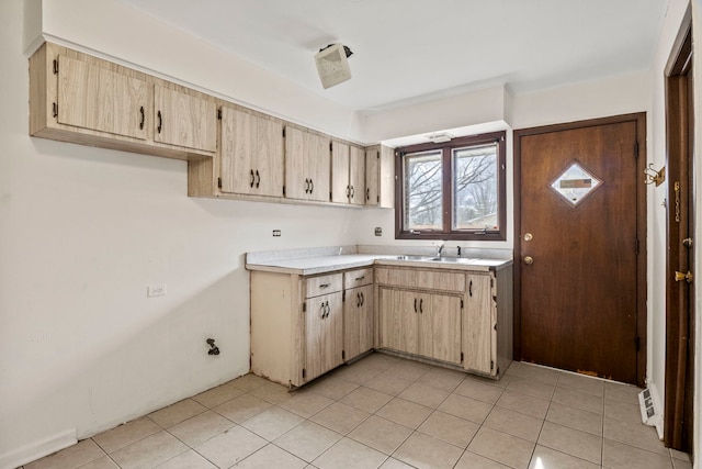 kitchen featuring light tile patterned floors, light countertops, and a sink