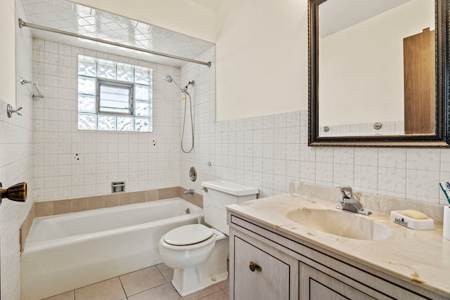 bathroom with tile patterned flooring, toilet, vanity, tile walls, and  shower combination