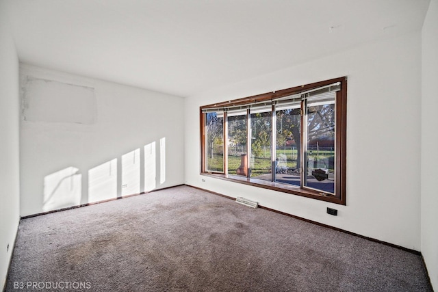 carpeted empty room featuring visible vents and baseboards